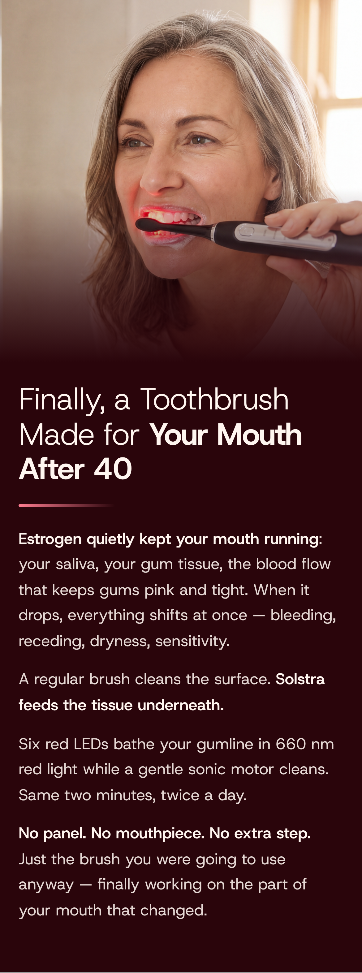 Finally, a Toothbrush Made for Your Mouth After 40. Estrogen quietly kept your mouth running: your saliva, your gum tissue, the blood flow that keeps gums pink and tight. When it drops, everything shifts at once — bleeding, receding, dryness, sensitivity. A regular brush cleans the surface. Solstra feeds the tissue underneath. Six red LEDs bathe your gumline in 660 nm red light while a gentle sonic motor cleans. Same two minutes, twice a day. No panel. No mouthpiece. No extra step. A grey-blonde woman brushes her teeth by a window, the Solstra brush head glowing red along her gumline.
