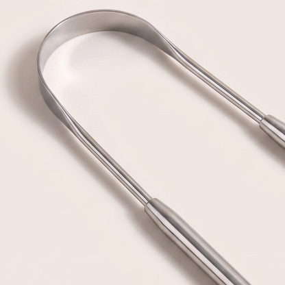 Close-up of the polished steel scraping edge of the tongue scraper