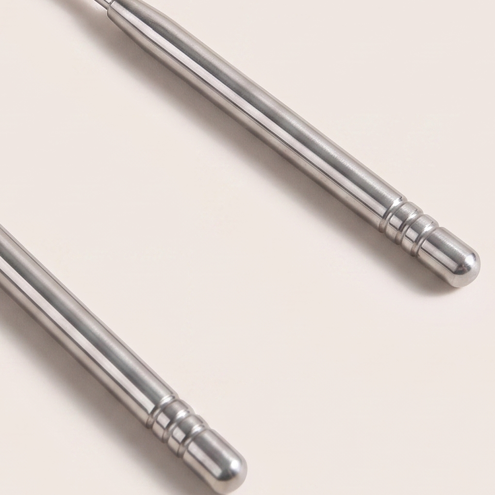 Close-up of the two ribbed handles and rounded tips of the tongue scraper