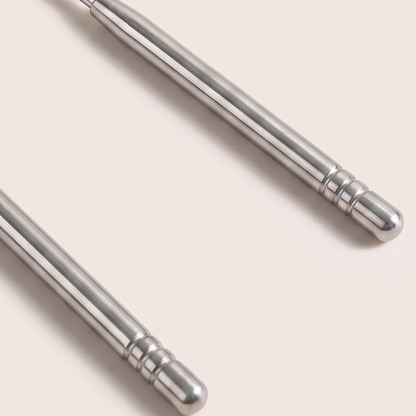 Close-up of the two ribbed handles and rounded tips of the tongue scraper